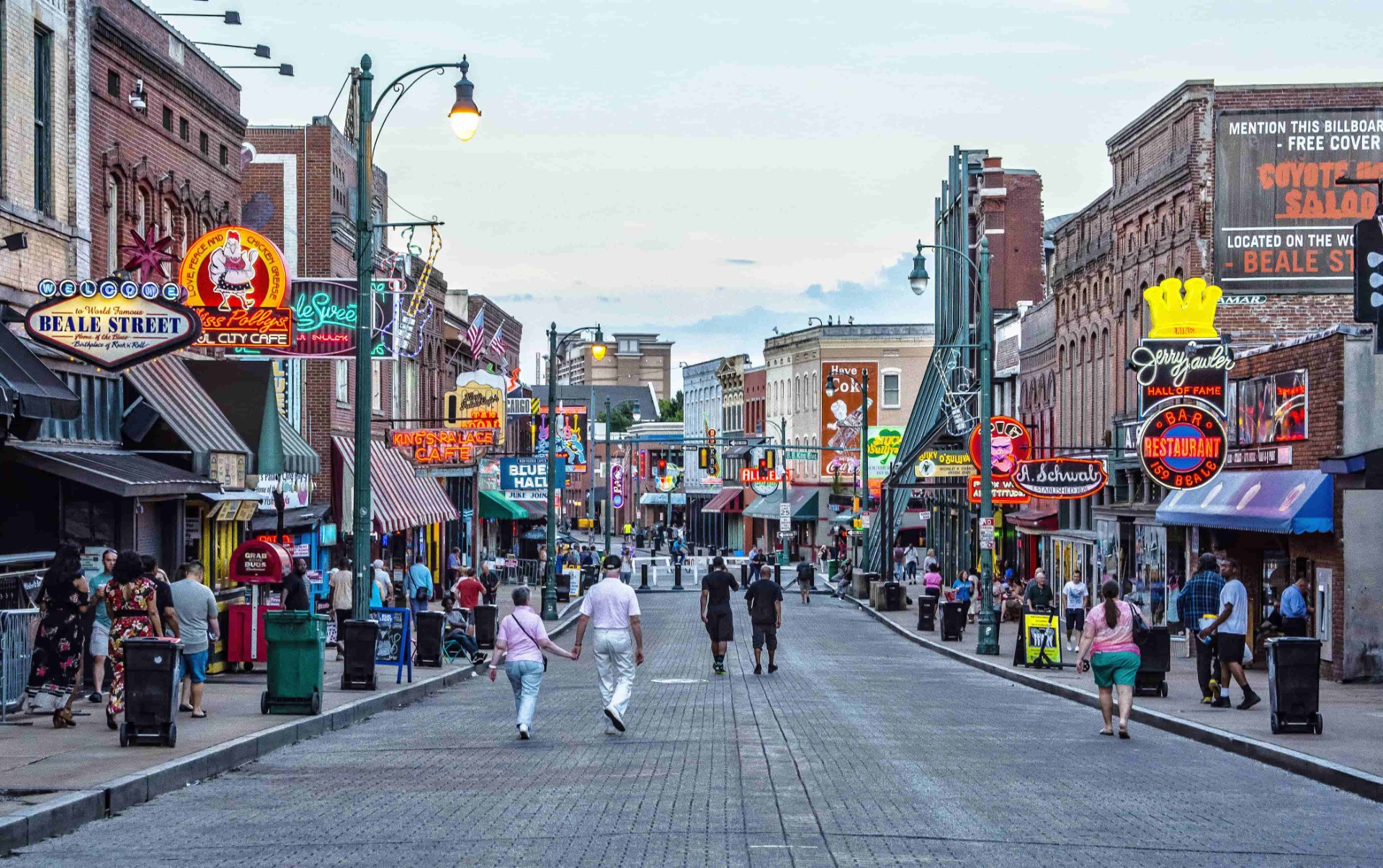 Belebte Straße mit Menschen, bunten Schildern und Reklamen, Blick auf Beale Street in der Ferne.